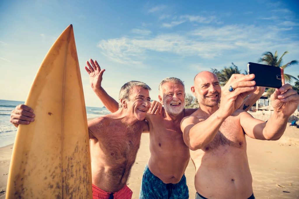 Group of senior men surfing on 2020 holiday