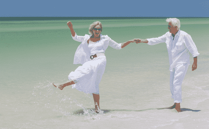 Over 50s Guide to Traveling in Spain: Old couple dancing in the ocean