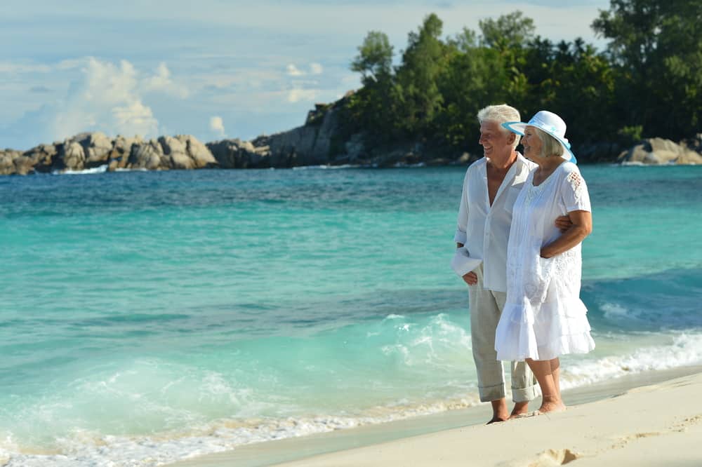 Holiday Curtailment Insurance: Senior couple on a beach