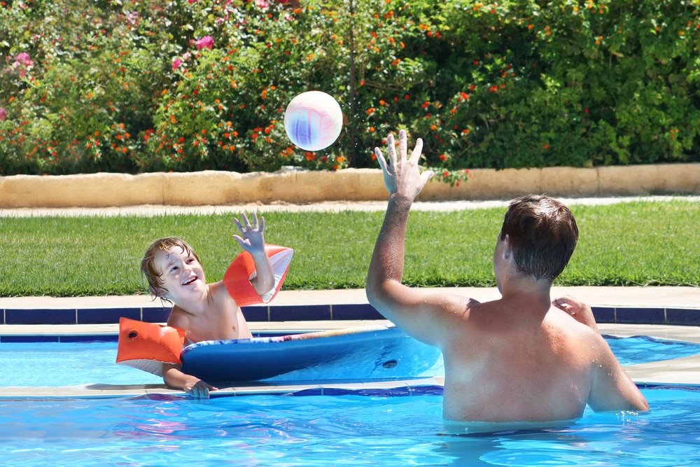 New study discovers how holidays help you live longer : Father and son playing in pool