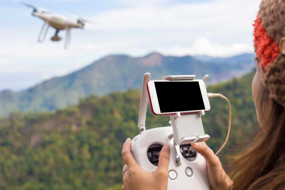 Best Holiday Gadgets / Covers Explained: Woman flying drone over jungle