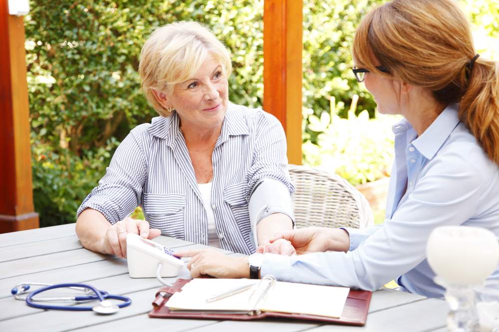 Know your numbers week: middle aged woman getting her blood pressure checked by doctor