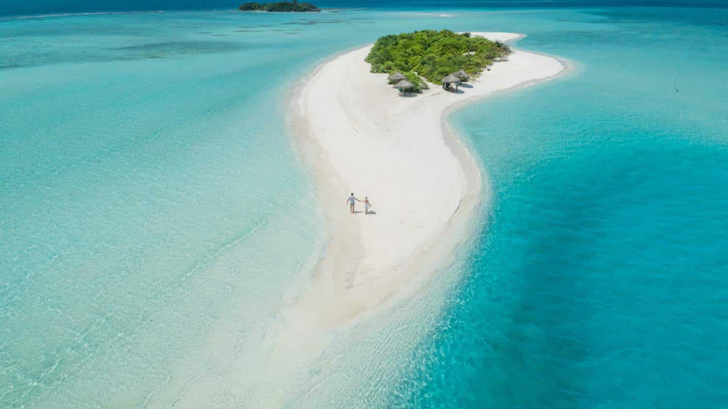 The worst destinations to fall ill on holiday: Drone picture of couple holding hands on island