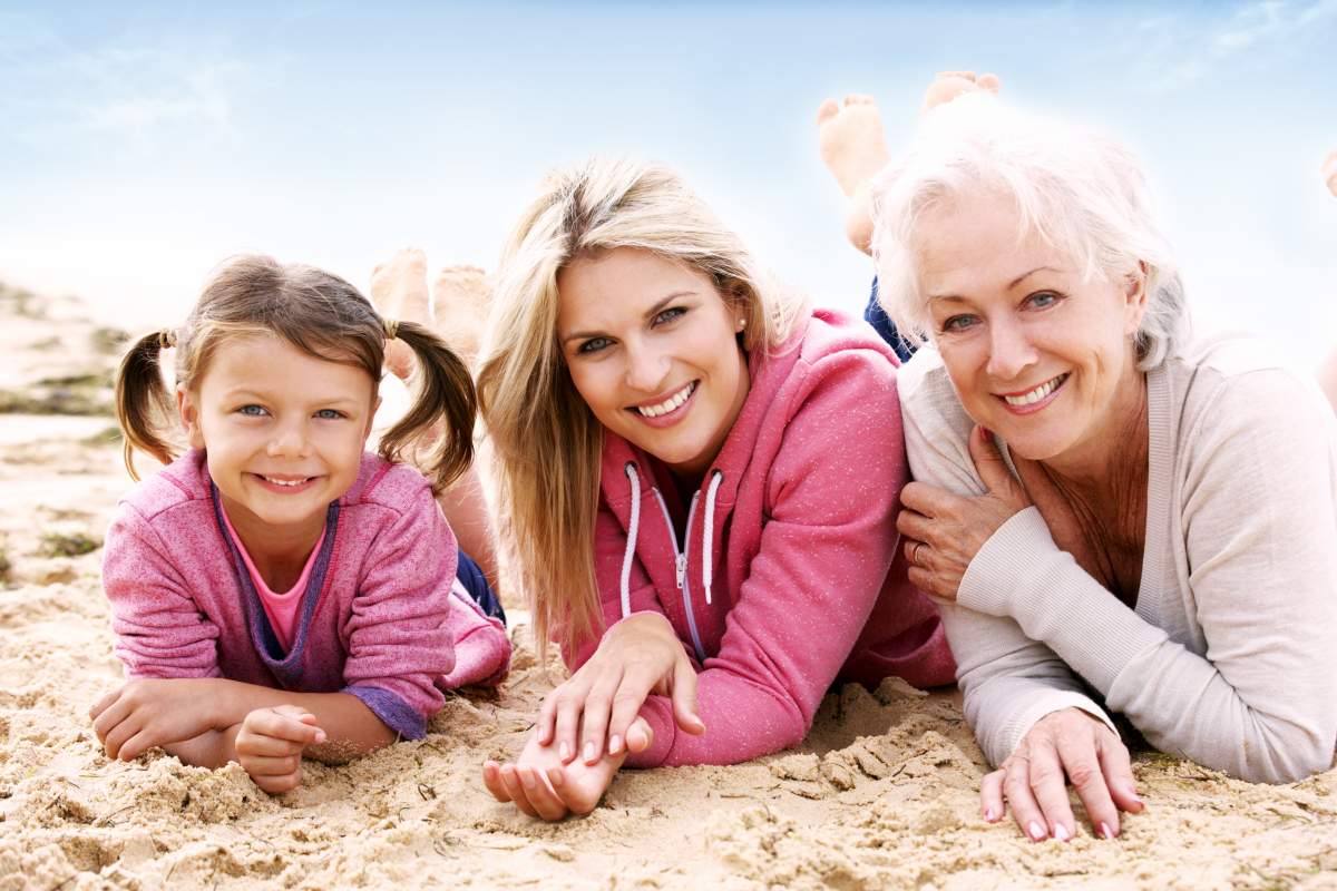 Travelling with breast cancer: grandmother, mother and daughter relaxing on the beach
