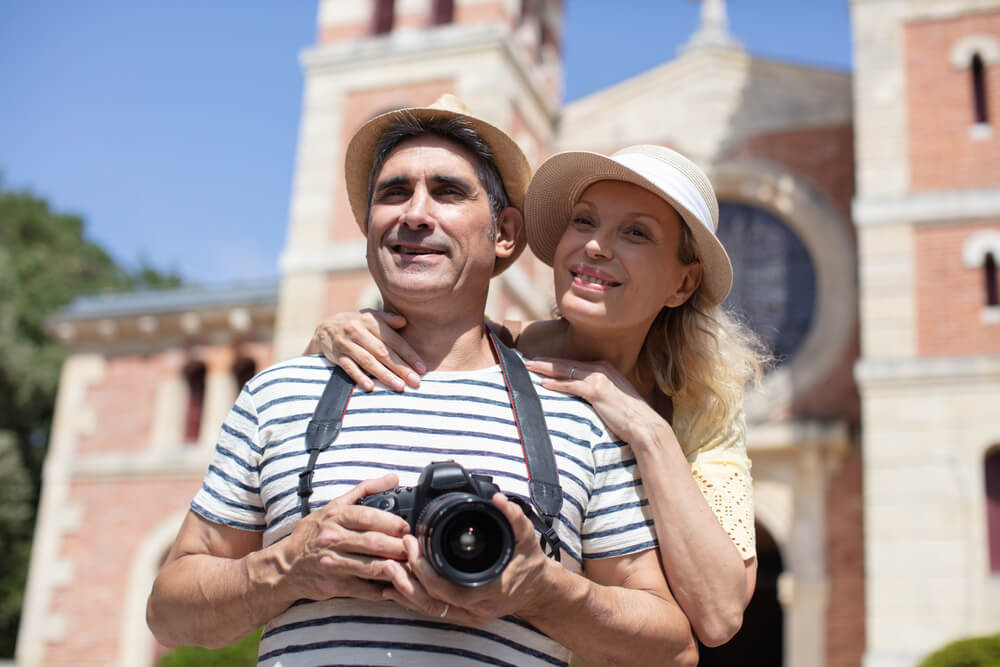 Picture shows a happy middle aged couple in a sunny destination