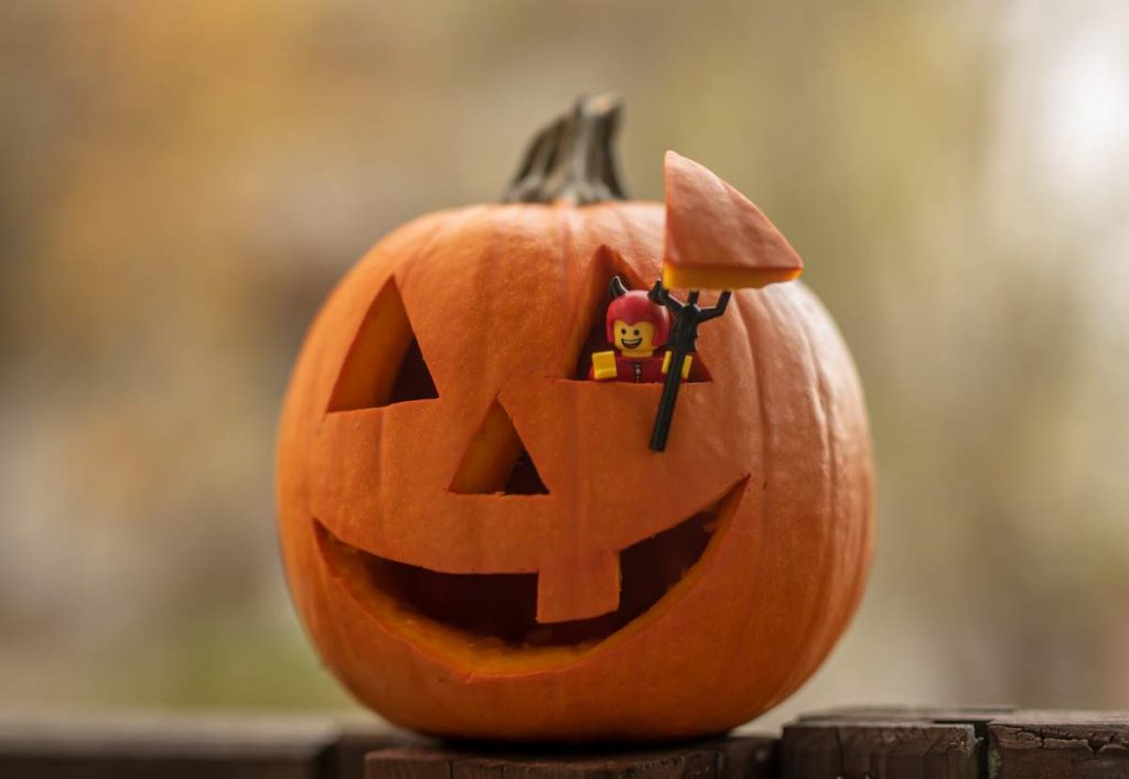 8 Spooky Destinations for a Halloween Holiday: Lego figure handing from Halloween pumpkin