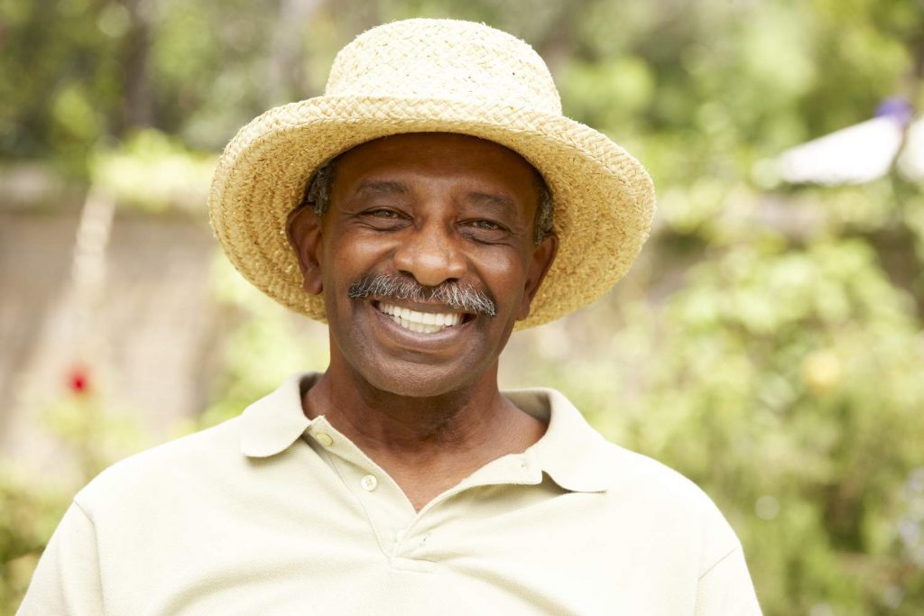 A happy mature man with a moustahce enjoying his holiday in a straw hat in a A Guide for Movember 2019