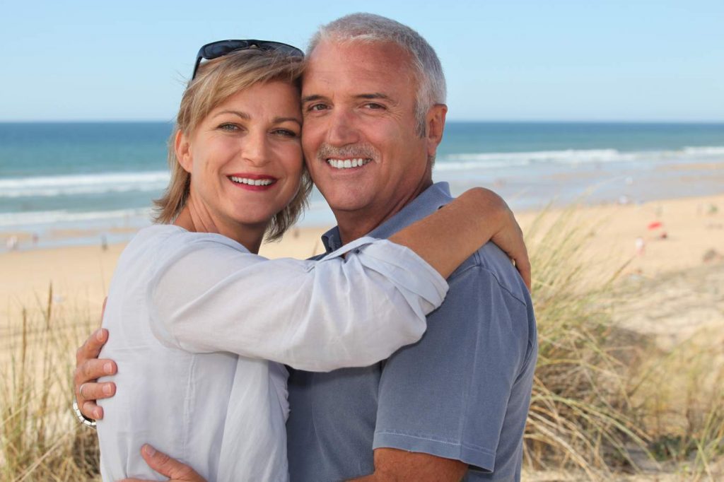 Happy middle aged couple on holiday including a man with a Movember moustache