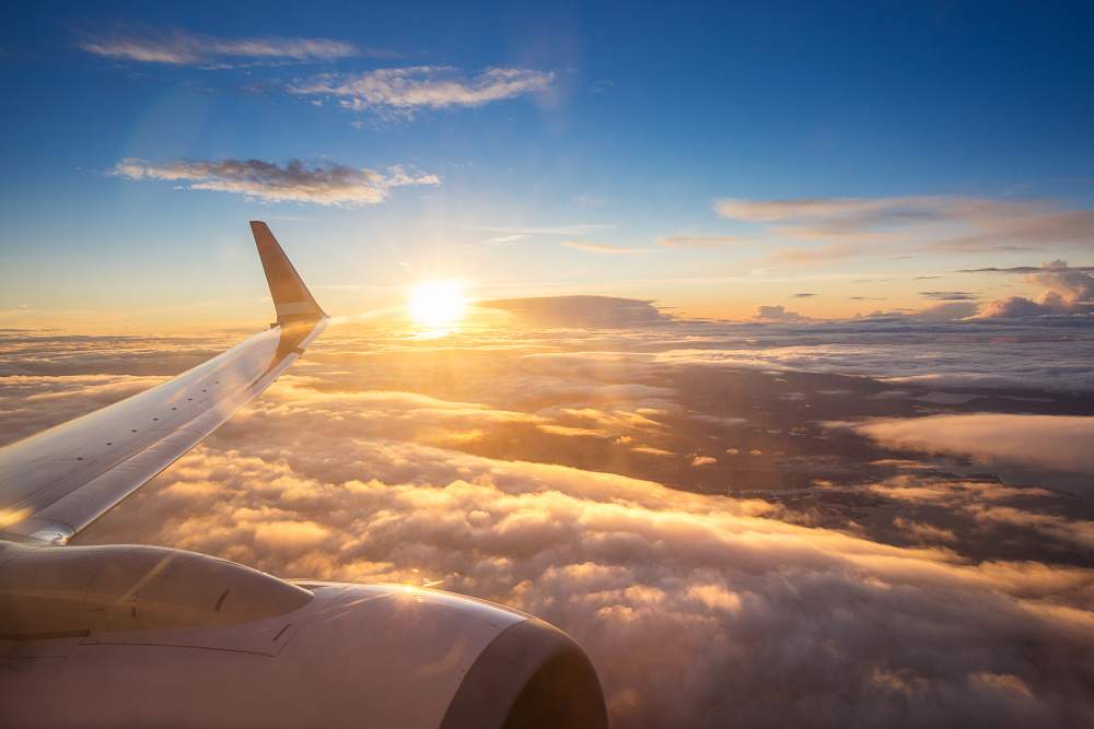 A Guide to Insurance When Airlines or Travel Companies Go Bust: View of couds and sun from plane window