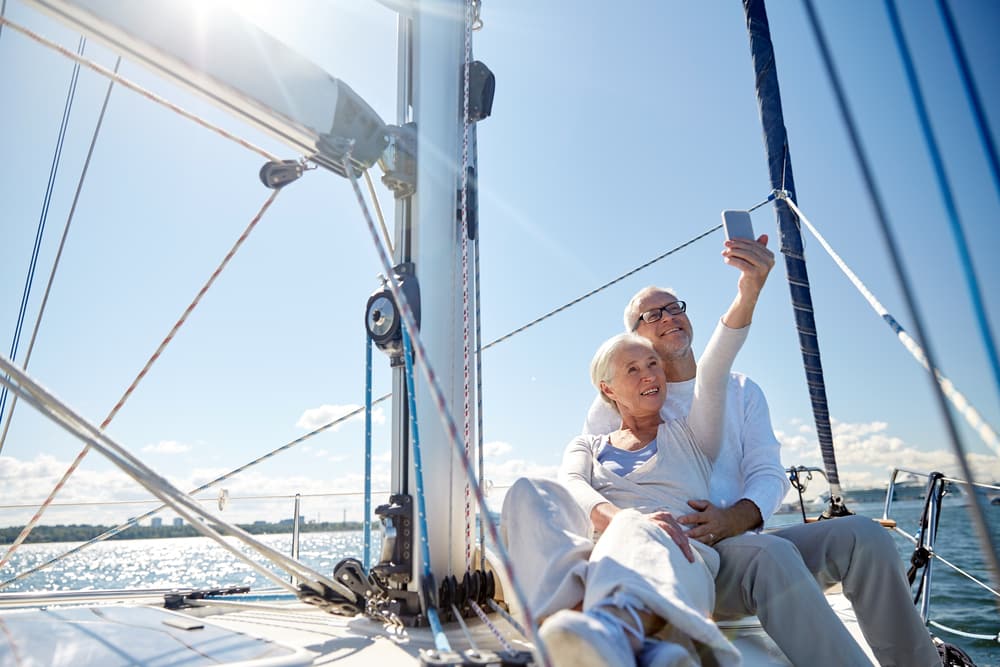 Do I Need Travel Insurance? Is It Worth It? Old couple on a cruise taking a selfie