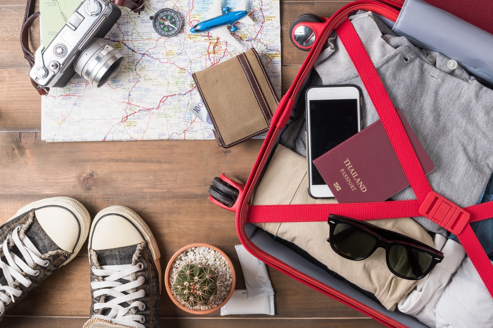 Do I Need Travel Insurance? Is It Worth It? Holiday suitcase and travel items