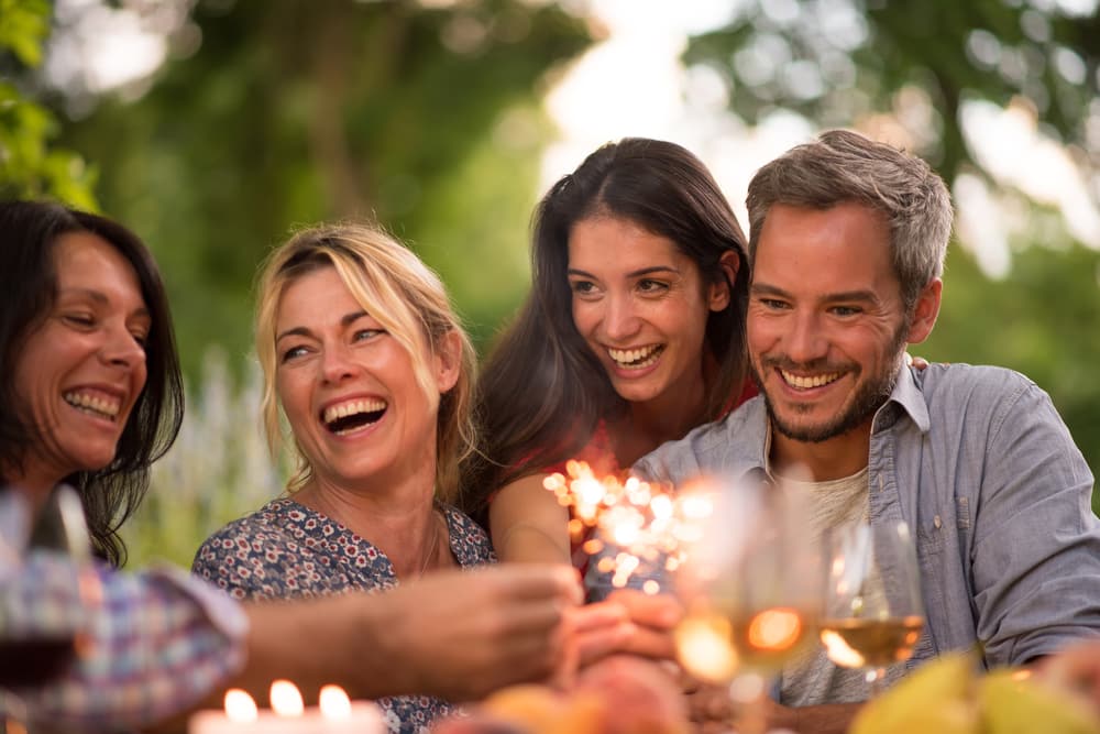 Travelling with a mental health condition: Group of friends laughing at party