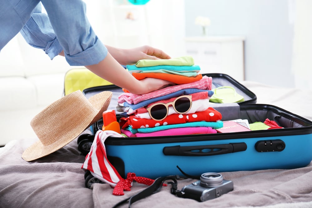 Travelling With Medications | Hand Luggage Restrictions: Woman packing her suitcase